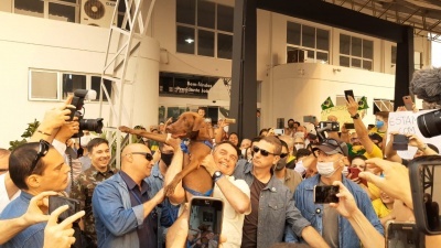 Stopa, o cão mascote, é abraçado por Jair Bolsonaro em visita oficial