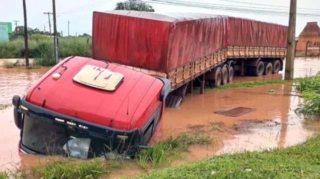 Carreta sai de pista alagada e cai em vala de escoamento de água em Sinop