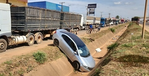 Carro cai em valeta após ser atingido por carreta