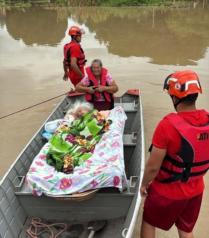 Bombeiros usam embarcação para resgatar idosa acamada e filha ilhadas em alagamento de MT